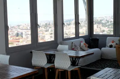 a living room with a table and a couch and windows at Le Panoramic Boutique Hôtel in Nice