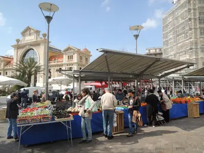 a group of people standing at a farmers market at Le Coin Du Marché in Nice