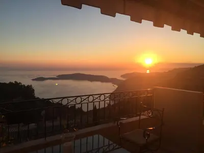 a sunset from the balcony of a house with the sun setting at Sunny Panoramic Balcony in Èze
