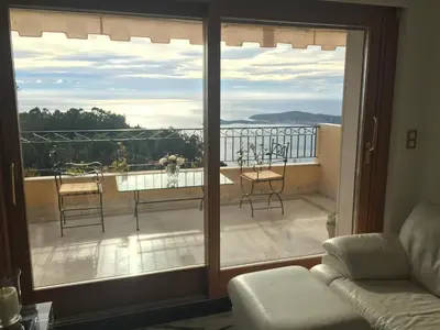 a living room with a view of a balcony at Sunny Panoramic Balcony in Èze