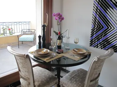 a dining room table with two chairs and a table with glasses at Sunny Panoramic Balcony in Èze
