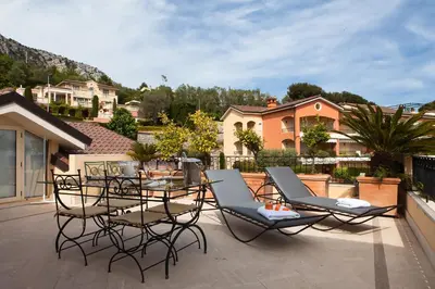 a patio with chairs and a table on a balcony at Sunny Panoramic Balcony in Èze