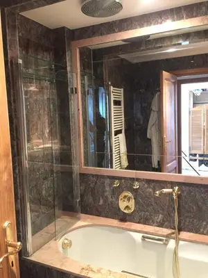 a bathroom with a bath tub with a mirror at Sunny Panoramic Balcony in Èze