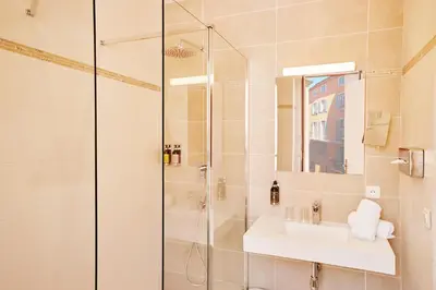 a bathroom with a shower and a sink at Welcome Hotel in Villefranche-sur-Mer