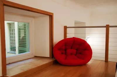 a red chair sitting in the corner of a room at Apartment Massena - Old Town in Nice