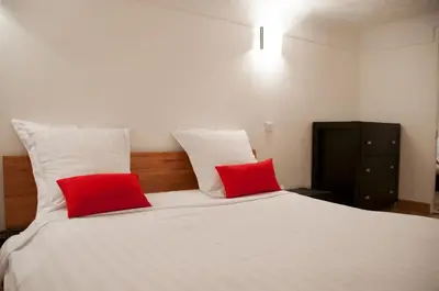a bedroom with a white bed with two red pillows at Apartment Massena - Old Town in Nice