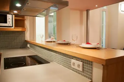 a kitchen with a counter with plates and wine glasses at Apartment Massena - Old Town in Nice