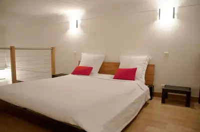 a bedroom with a white bed with two red pillows at Apartment Massena - Old Town in Nice