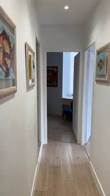 a hallway with white walls and a hallway with paintings on the walls at 2 Bedrooms Appartement In Central Location on the famous Place Massena Nice in Nice