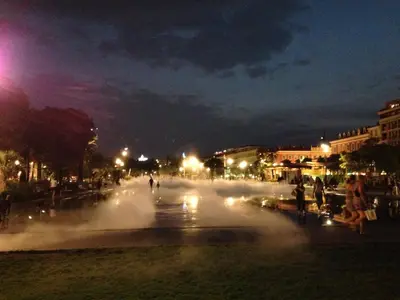 a fountain in the middle of a city at night at 2 Bedrooms Appartement In Central Location on the famous Place Massena Nice in Nice