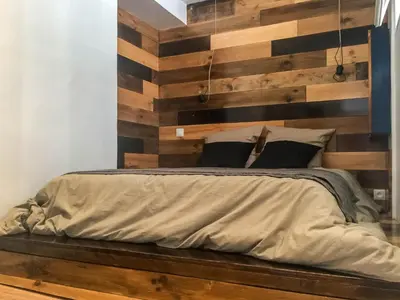 a bedroom with a wooden wall with a bed at Nicolago in Nice