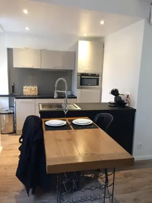 a kitchen with a wooden table and a sink at Nicolago in Nice