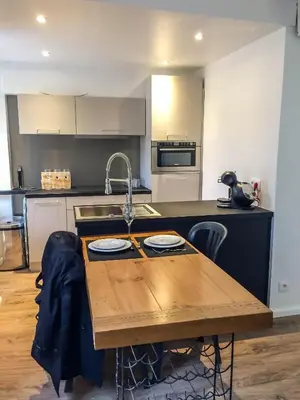 a kitchen with a wooden table and a sink at Nicolago in Nice