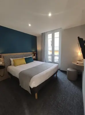 a bedroom with a large bed and a large window at Bristol Nice in Nice