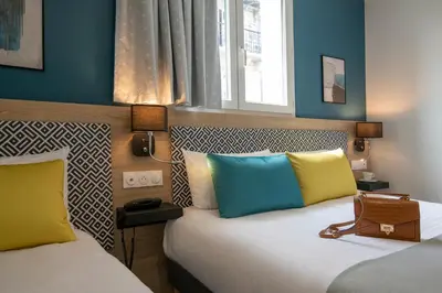 two beds in a room with blue walls at Bristol Nice in Nice
