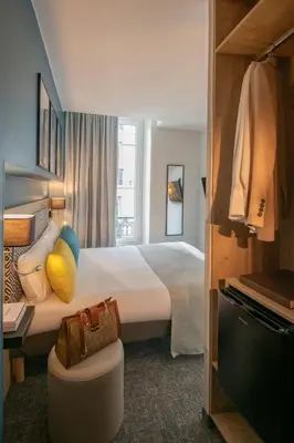 a hotel room with a large bed and a chair at Bristol Nice in Nice