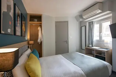 a bedroom with a bed and a desk and a window at Bristol Nice in Nice