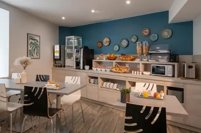 a kitchen with a table and chairs and a counter at Bristol Nice in Nice