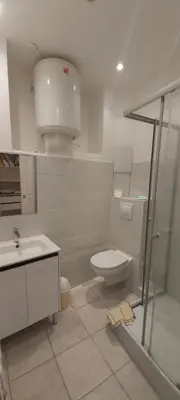 a bathroom with a toilet and a sink and a shower at Studio dans la Villa 