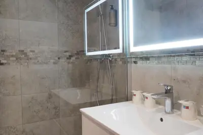 a bathroom with a toilet and a sink and a shower at Hotel Busby in Nice