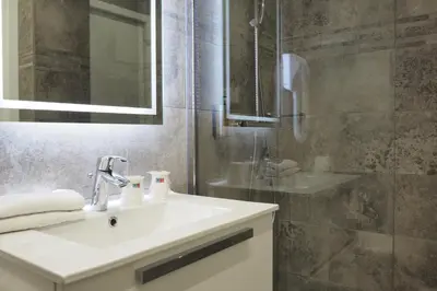 a bathroom with a sink and a shower at Hotel Busby in Nice