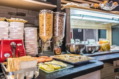a buffet with bread and food on a counter at Hotel De Suède in Nice