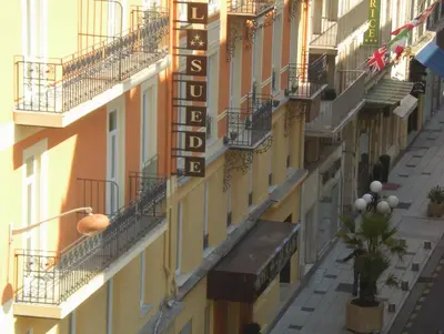 a building with a hotel sign on the side of it at Hotel De Suède in Nice