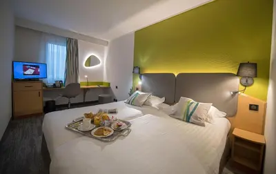 a hotel room with a bed with a tray of food on it at Promotel in Carros