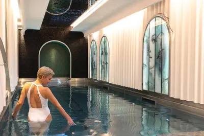 a woman is standing in a swimming pool at Hotel Le Negresco in Nice