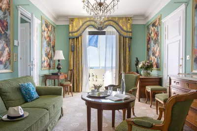 a living room with a couch and a table at Hotel Le Negresco in Nice