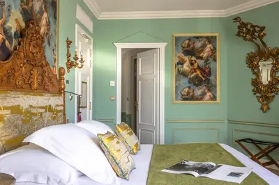 a bedroom with a bed with a painting on the wall at Hotel Le Negresco in Nice