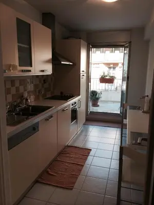 a kitchen with white cabinets and a sink and a window at Appartamento Sole in Nice