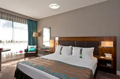 a lobby with a table and chairs and a couch at Holiday Inn Nice by IHG in Nice