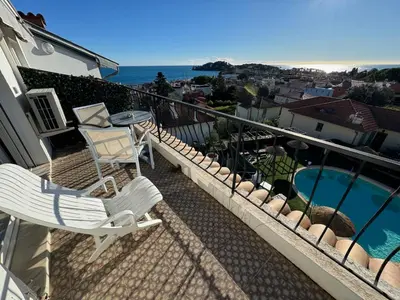 a balcony with two chairs and a table and a pool at Boutique Hotel & Spa la Villa Cap Ferrat in Saint-Jean-Cap-Ferrat