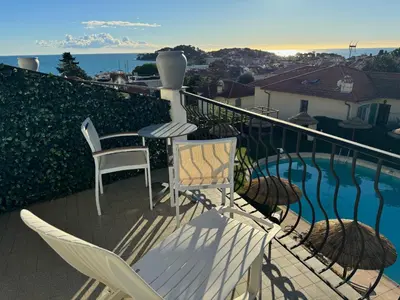 a balcony with chairs and a table and a pool at Boutique Hotel & Spa la Villa Cap Ferrat in Saint-Jean-Cap-Ferrat