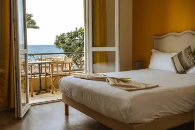 a bedroom with a bed and a view of the ocean at Hôtel du Bord de Mer 