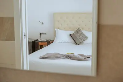 a bedroom with a white bed with a mirror at Hôtel du Bord de Mer 