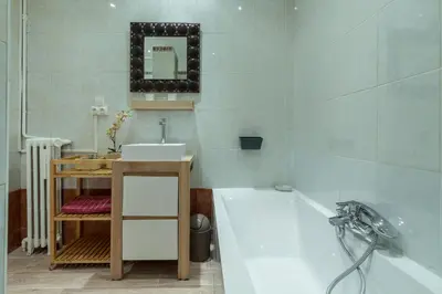 a bathroom with a tub and a sink and a mirror at Beautiful apartment by the sea front in Nice