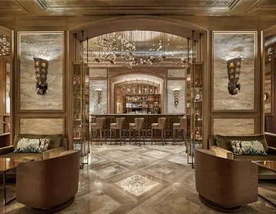 a lobby with a bar with chairs and a chandelier at La Réserve de Beaulieu in Beaulieu-sur-Mer