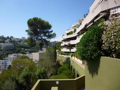 an apartment building with a tree on the side of it at Nice-Miramar Apartment and Parking in Nice