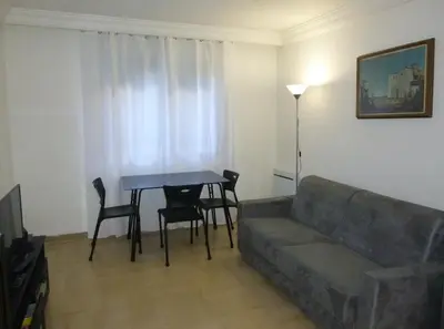 a living room with a couch and a table and chairs at Nice-Miramar Apartment and Parking in Nice