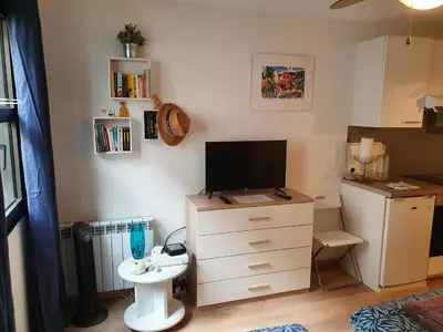 a living room with a tv and a dresser with a tvicterictericter at Oranger in Nice