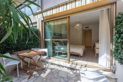 a glass patio with a table and a bed at CENTRE PROMENADE Golden Square Terrace 1 min Walk to the Beach AC in Nice