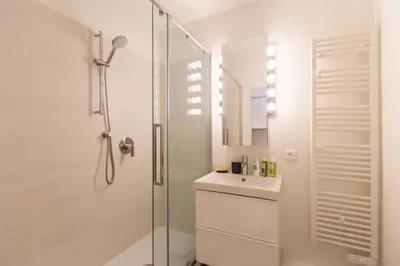 a white bathroom with a shower and a sink at CENTRE PROMENADE Golden Square Terrace 1 min Walk to the Beach AC in Nice