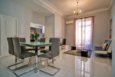 a dining room with a glass table and chairs at Designer Flat Nice in Nice