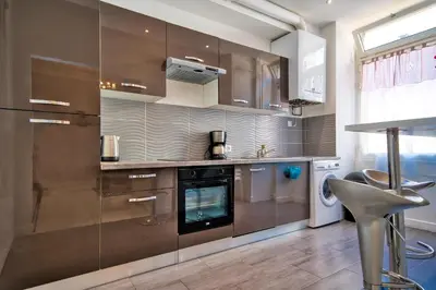 a kitchen with stainless steel appliances and a chair at Designer Flat Nice in Nice