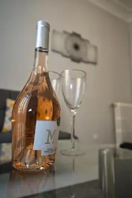 a bottle of wine sitting next to a wine glass at Designer Flat Nice in Nice