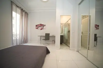 a bedroom with a bed and a desk and a mirror at Designer Flat Nice in Nice