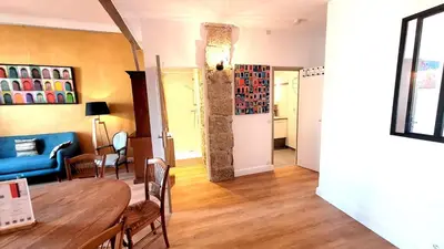 a living room with a table and a blue couch at ZePerfectPlace - Vieux Nice Garibaldi 3 chambres in Nice