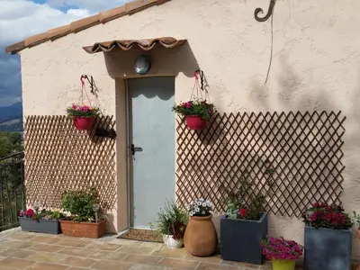 a house with potted plants on the side of it at La Tuiliere in Saint-Laurent-du-Var